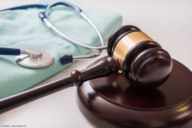 Gavel with stethoscope resting on medical scrubs in the background | Image Credit: © vchalup - stock.adobe.com